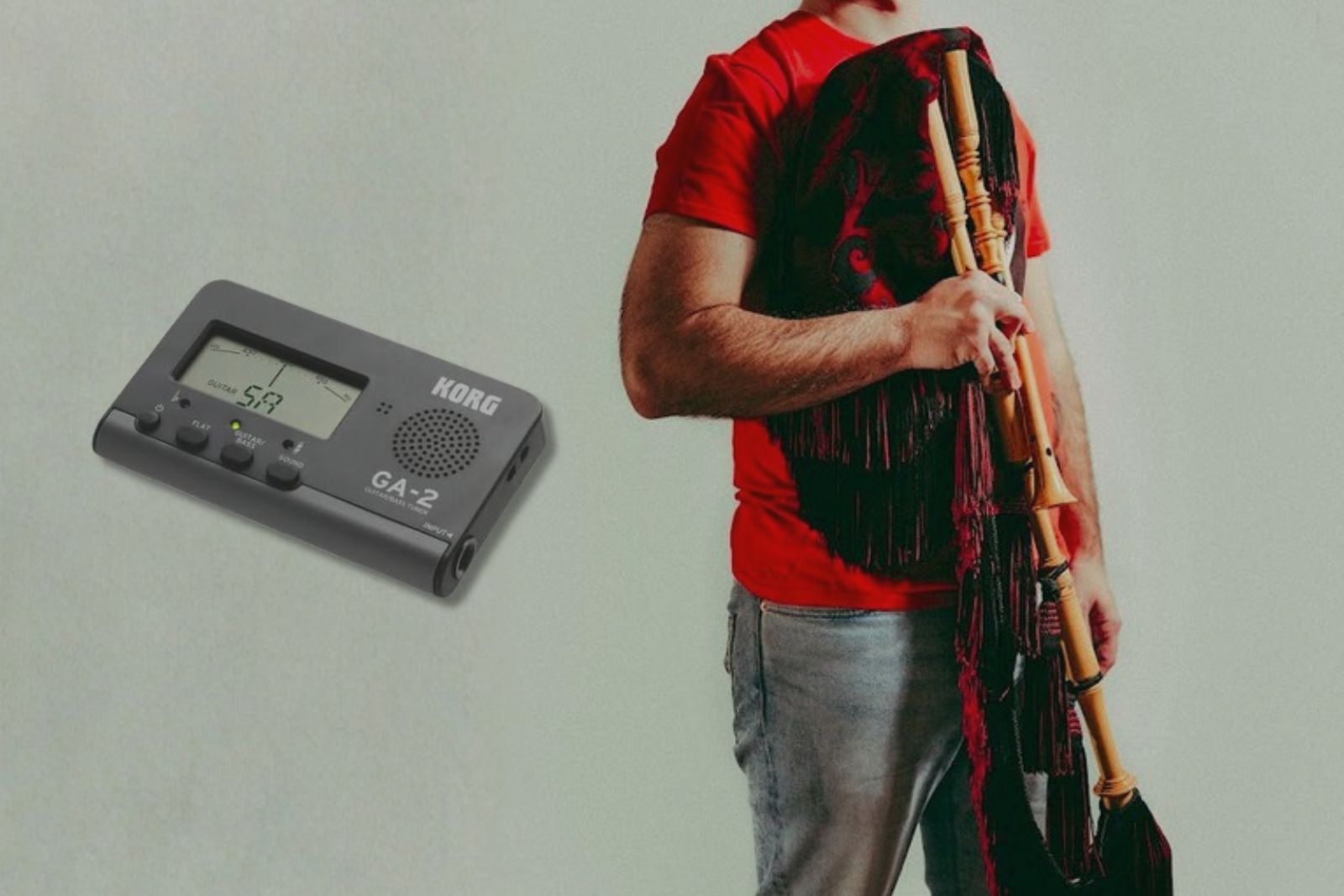 Un gaitero tenant la gaita asturienne avec le roncón posé sur l'épaule, à côté d'un accordeur chromatique Korg GA-2 utilisé pour accorder le bourdon